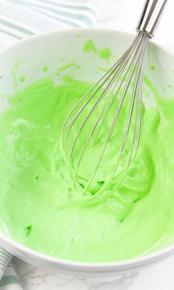 green whipped topping in bowl with whisk