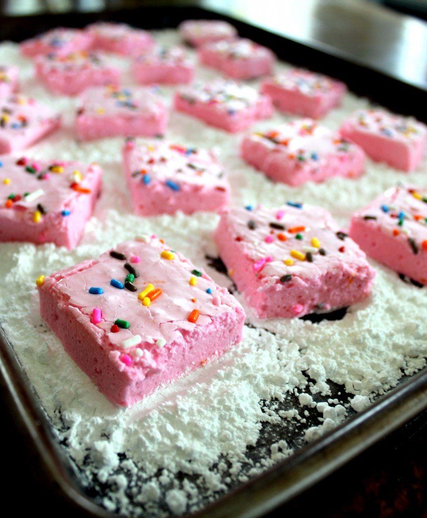 pink marshmallows on baking sheet with powdered sugar
