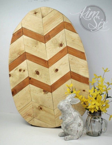 CHevron wooden egg on table with decor in front of it 