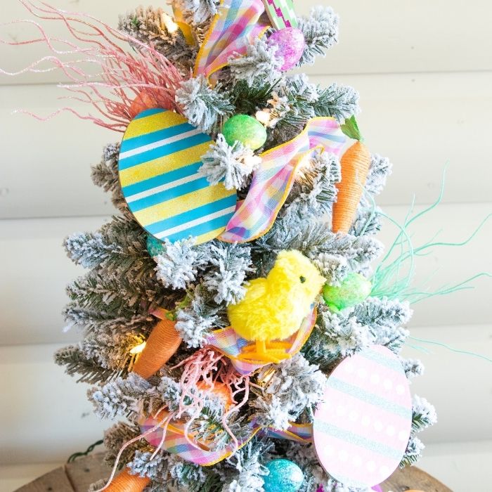 Check out this Dollar Tree Easter Tree! You will decorate an indoor tree with festive and fun Easter decor found at the Dollar Tree! #easter #passion4savings #tree #homedecor #dollartree #easy #affordable #budget #homedecor #best #dollarstore An Easter decorated tree on table