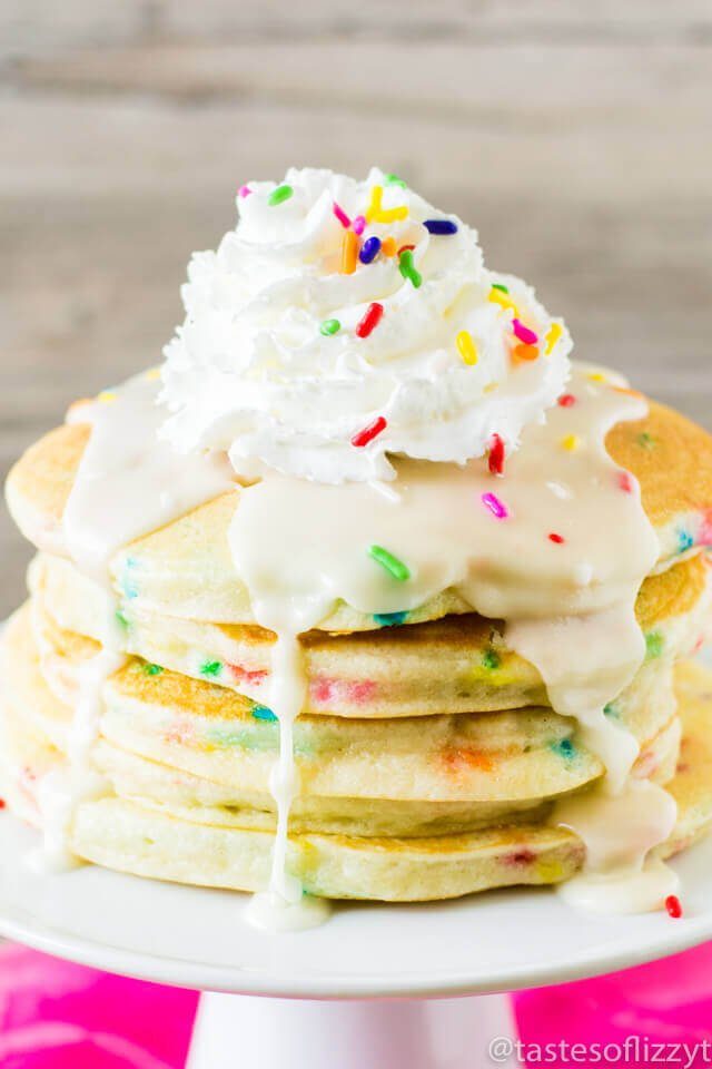 stack of pancakes with whipped cream and sprinkles on top 