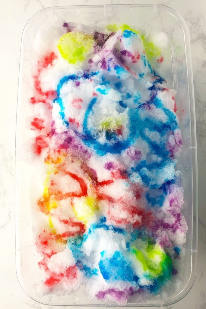 Check out these indoor snow painting activity for kids! A fun way to bring the winter snow indoors for kids to play with in a colorful way. #passion4savings #snow #indoors #fun #activity #diy #easy #kids #forkids #diyfun #activity #snowpainting painted snow in plastic container on floor