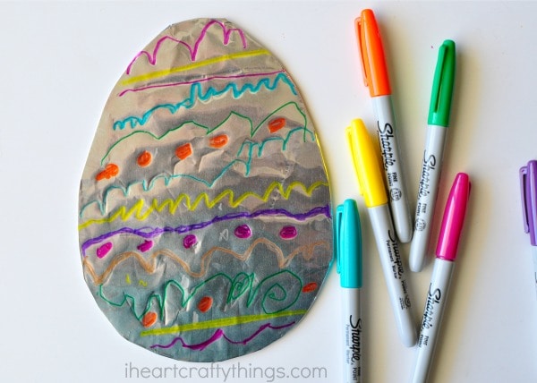 aluminum foil decorated easter egg with sharpies by it 