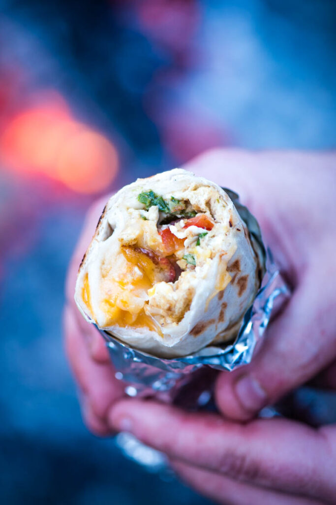 breakfast burrito in foil being held 