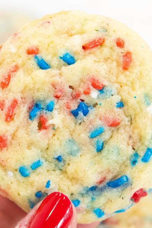 Here are delicious 4th of July Sprinkle Cookies for you to make and serve up for your 4th of July summer bash! Easy cookies, fun, and tasty. #passion4savings #sprinkles #4thofjuly #patriotic #dessert #summer #cookies cookie being held
