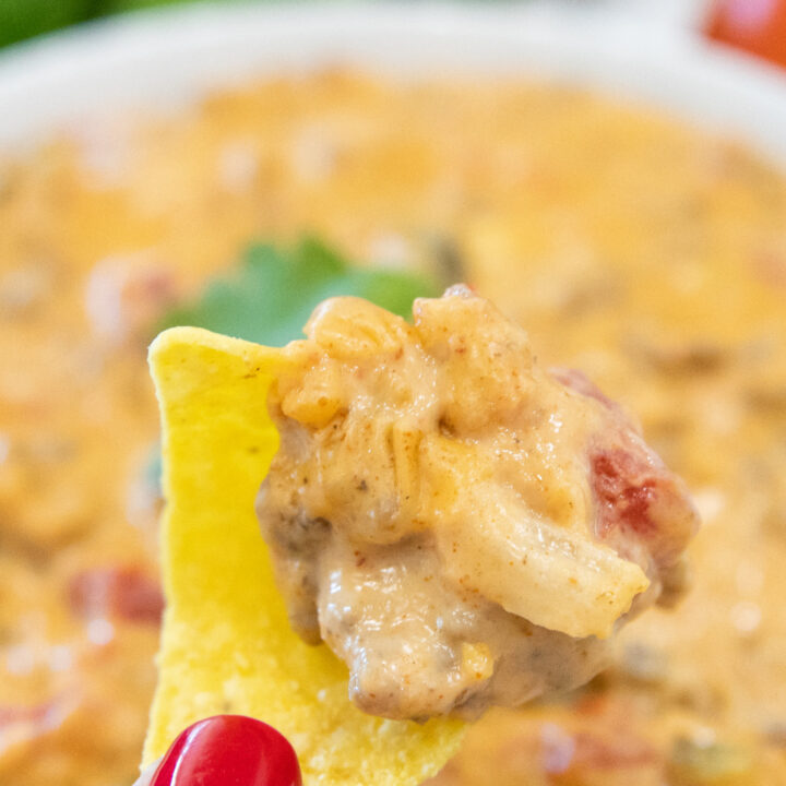 smoked queso dip on a tortilla chip in the hand
