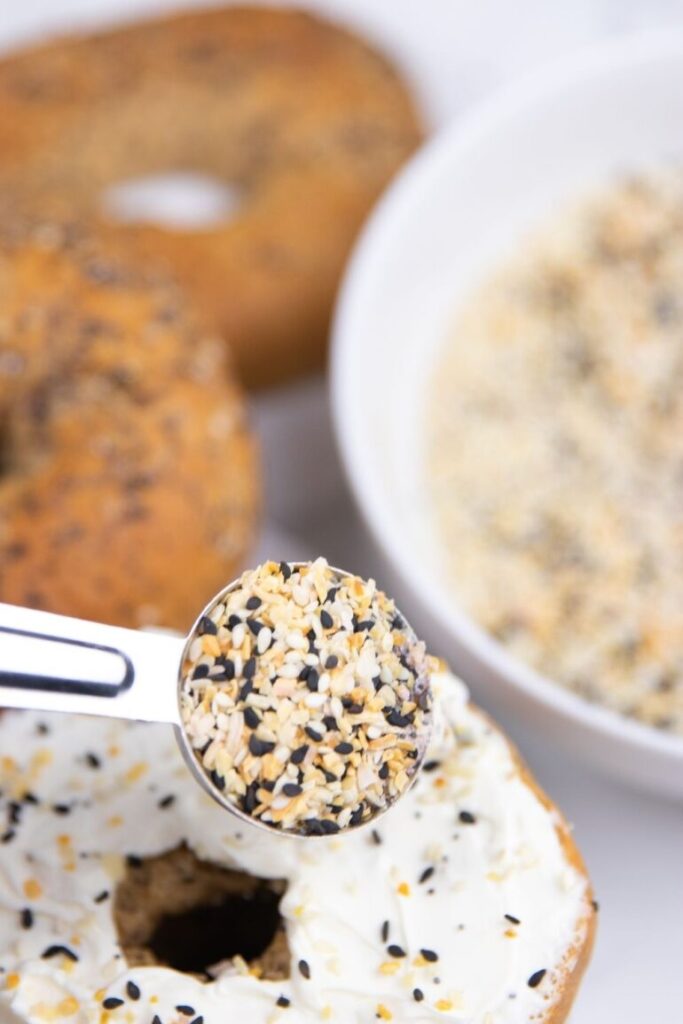 spoon of bagel seasoning over a bagel