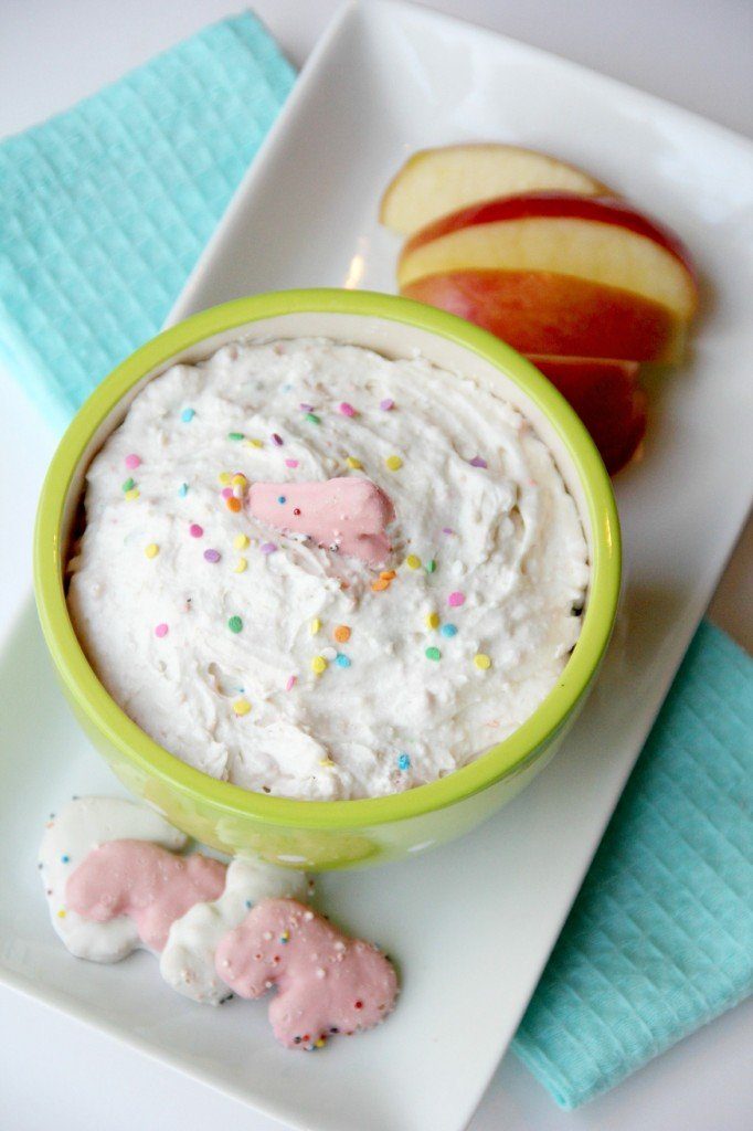 fruit dip with cookie in center on platter with apple slices by it 