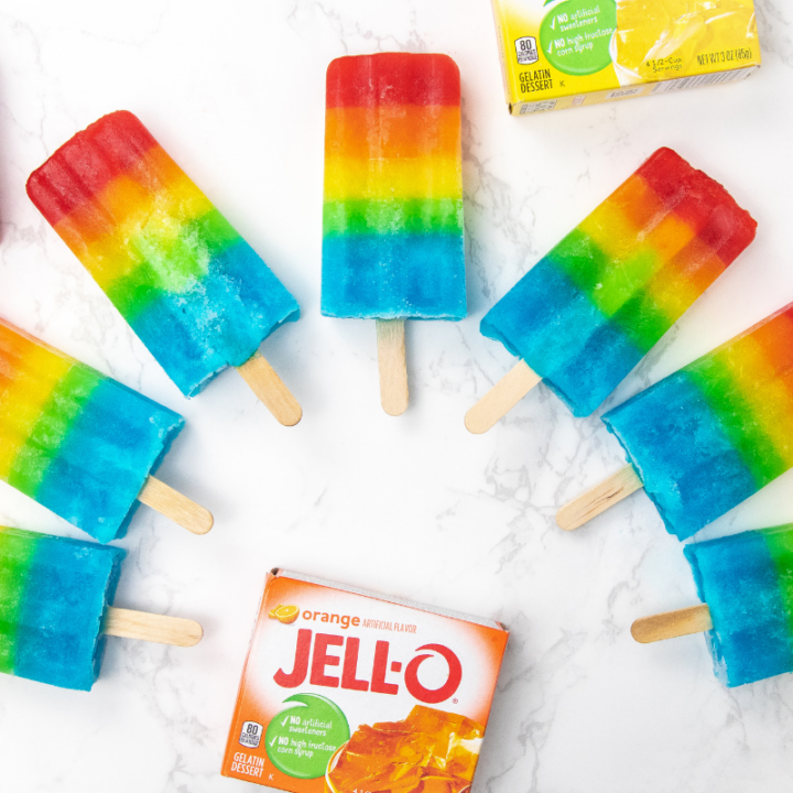 popsicles shaped like a rainbow on counter with Jello box by it