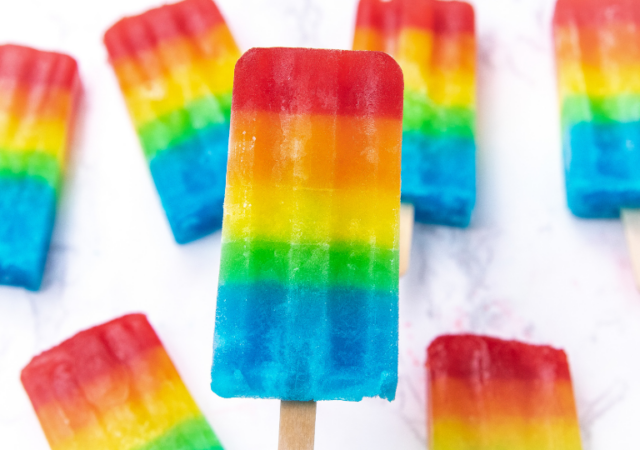 holding a rainbow frozen popsicle
