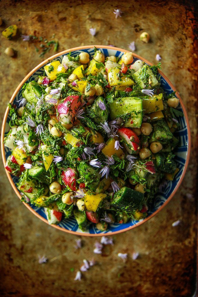 overhead shot of a Persian chopped salad in brown bowl and brown table 