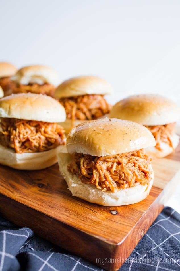 Serve up one or more of these Genius slider recipes. A simple slider bun that is filled with all your favorite fixings and baked to perfection! #passion4savings #sliders #easy #appetizer #dinner #simple #quick #nofuss wood cutting board with bbq chicken sliders on it