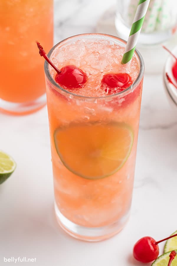 cherry limeade drink in a glass with cherries on top 