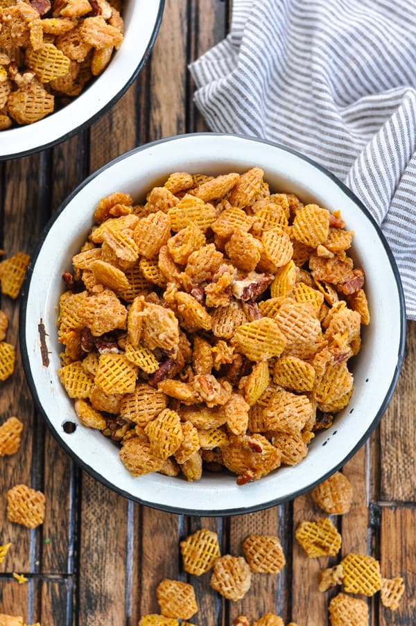 snack mix in a white bowl on wood counter 