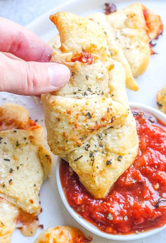 dipping pizza roll in sauce 