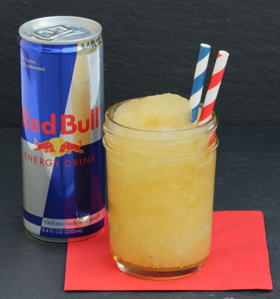 Red bull can and slush sitting on a red napkin 