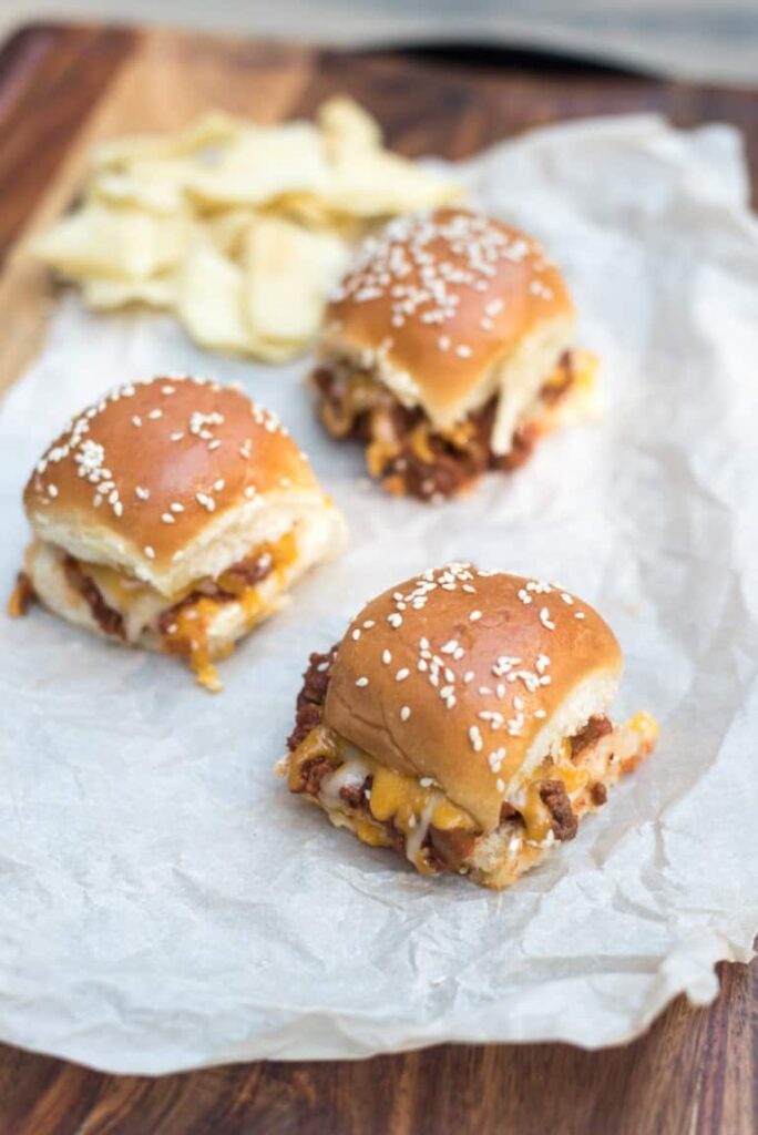 parchment paper with sloppy joe sliders placed on it and chips 