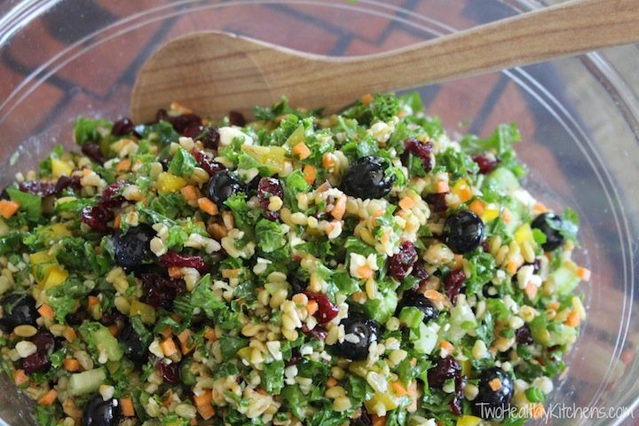 head view of kale salad in a bowl with wooden spoon