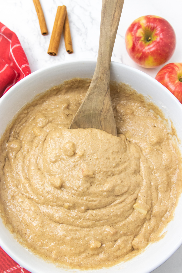 3 ingredients is all it takes to make these cake mix apple spice muffins! A delicious fresh apple muffin that is a breakfast or dessert! #passion4savings #apple #muffins #freshapples #easy #quick #cakemix #fall #fallmuffin batter for apple muffins with wooden spoon in it