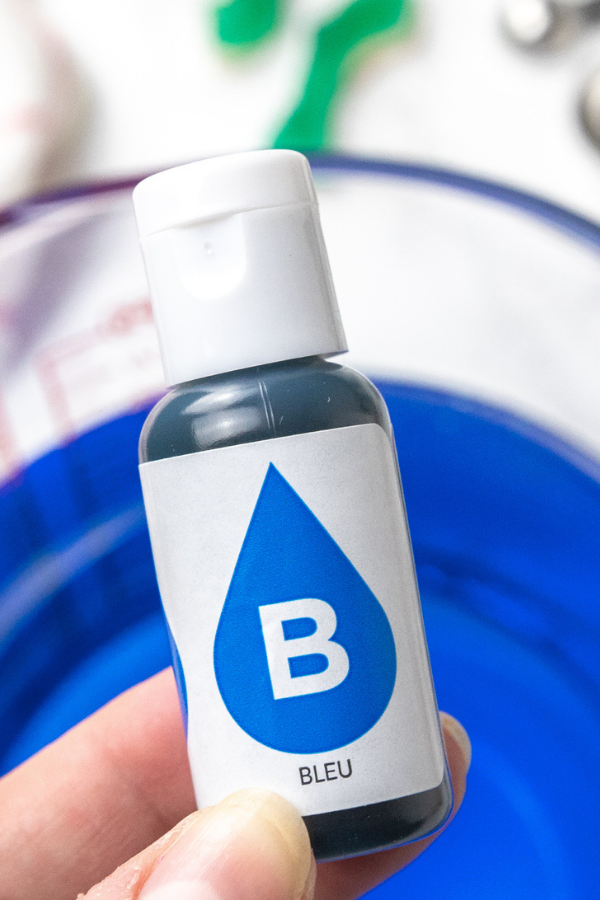 Serve up this delicious and easy shark week ocean water drink. A blue coconut ocean water that is topped with shark gummies! A must make! #passion4savings #shark #sharkweek #drink #oceanwater #drinkrecipe #bluecoconut #bluedrink #kidfriendly #familyfriendly blue food coloring over bowl