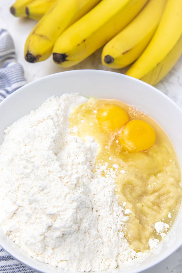 cake mix, eggs and bananas in a bowl on table 