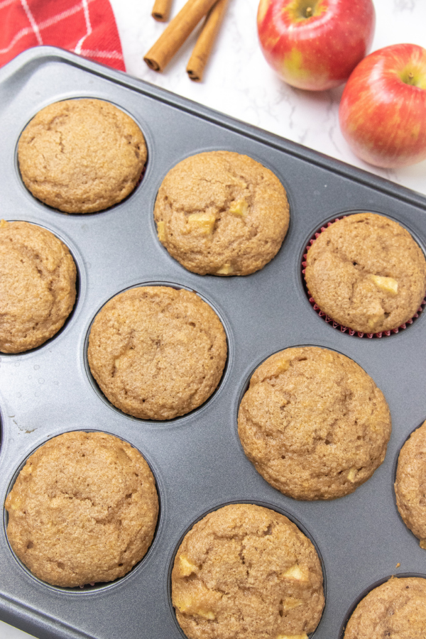 3 ingredients is all it takes to make these cake mix apple spice muffins! A delicious fresh apple muffin that is a breakfast or dessert! #passion4savings #apple #muffins #freshapples #easy #quick #cakemix #fall #fallmuffin side view of a muffin tin with apple muffins in it