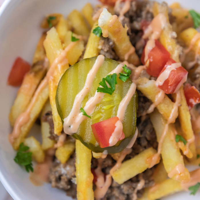 ground beef casserole on a plate with pickle on top