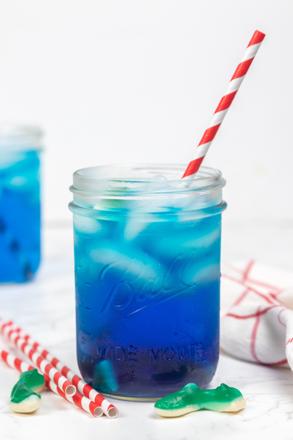 side shot of a blue shark week drink with red paper straw 