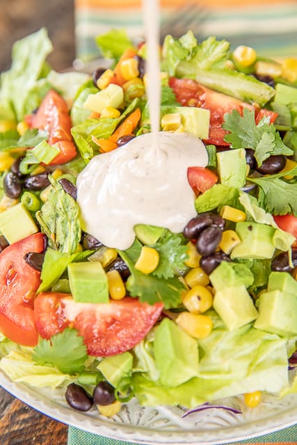 dressing being poured on salad