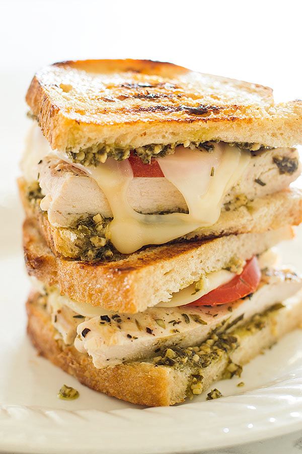 pesto chicken sandwich stacked up on plate 