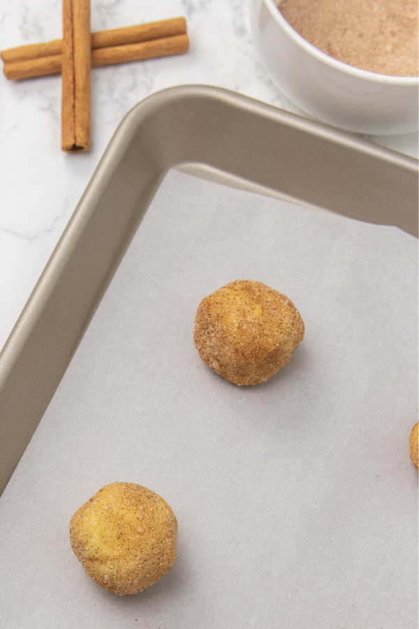 Whip up these cake mix snickerdoodles that take just 5 ingredients to make. A great beginners cookie recipe that is light and fluffy! #passion4savings #cakemix #cookies #snickerdoodles #easy #beginner #baker #holiday #cookieswap #simple snickerdoodles on baking sheet