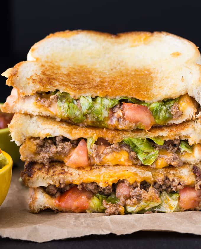stacked taco grilled cheese on a parchment paper counter 