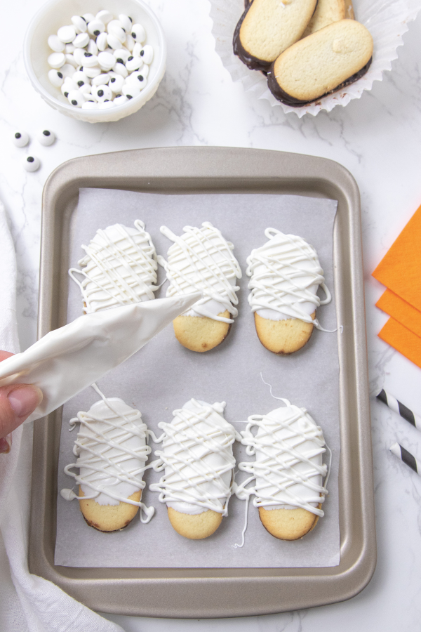 drizzling on chocolate on cookies 