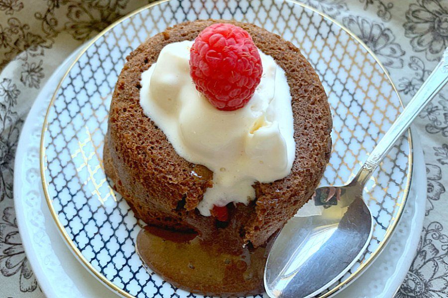 chocolate lava cake on plate with spoon by it 