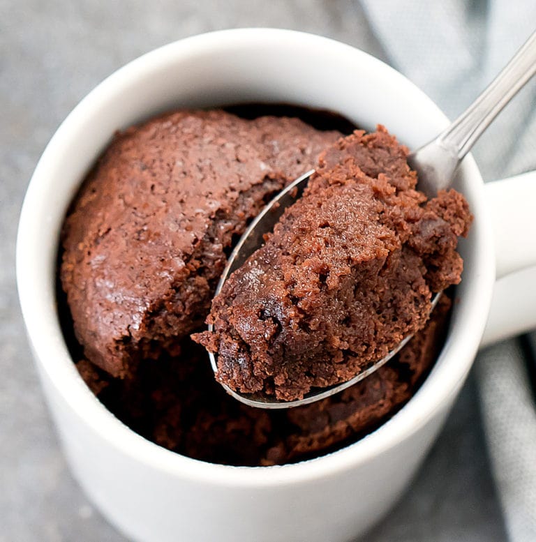 spoon with chocolate cake on it in a mug cake under 