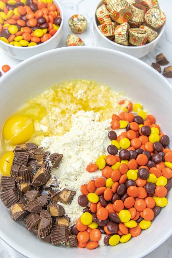 overhead shot of bowl with candies and cake mix, egg and butter inside