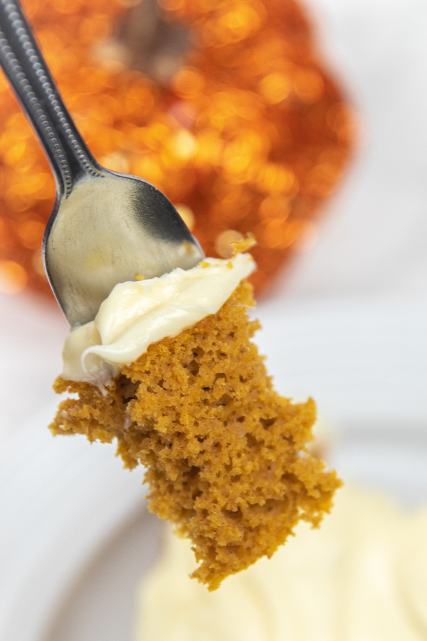 slice of cake with frosting on fork 