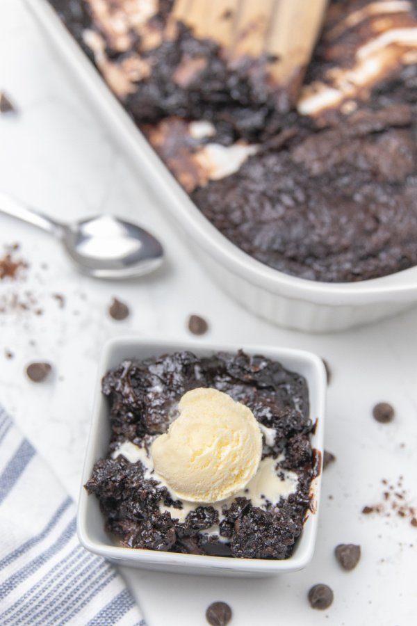 Serve up this incredible chocolate pudding cake. Layers of flavors that bake to a gooey pudding texture. A must make chocolate cake recipe. A melting cake that you will want to make over and over again. #cake #chocolate #magic #melting #pudding #rich #potluck #dessert #easy #homemade #fromscratch bowl with cake and ice cream on top