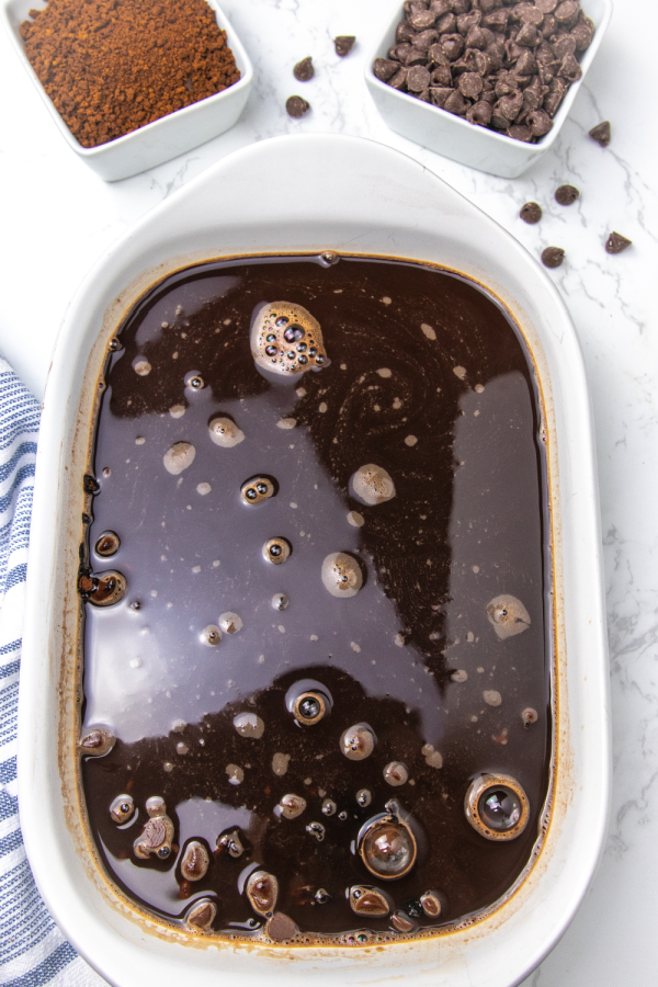 Serve up this incredible chocolate pudding cake. Layers of flavors that bake to a gooey pudding texture. A must make chocolate cake recipe. A melting cake that you will want to make over and over again. #cake #chocolate #magic #melting #pudding #rich #potluck #dessert #easy #homemade #fromscratch espresso mixture poured over cake batter