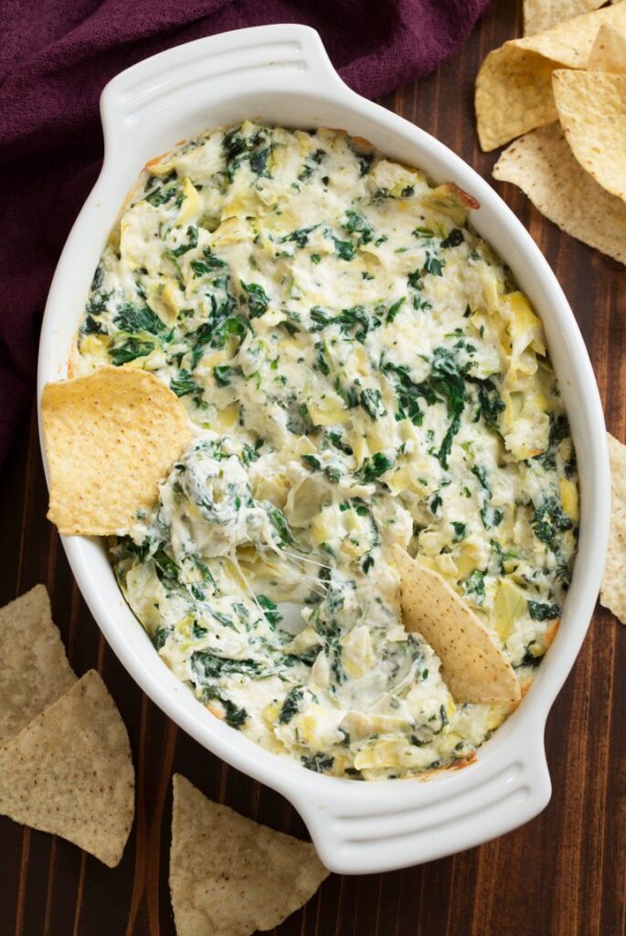 creamy spinach dip with chips sticking in it