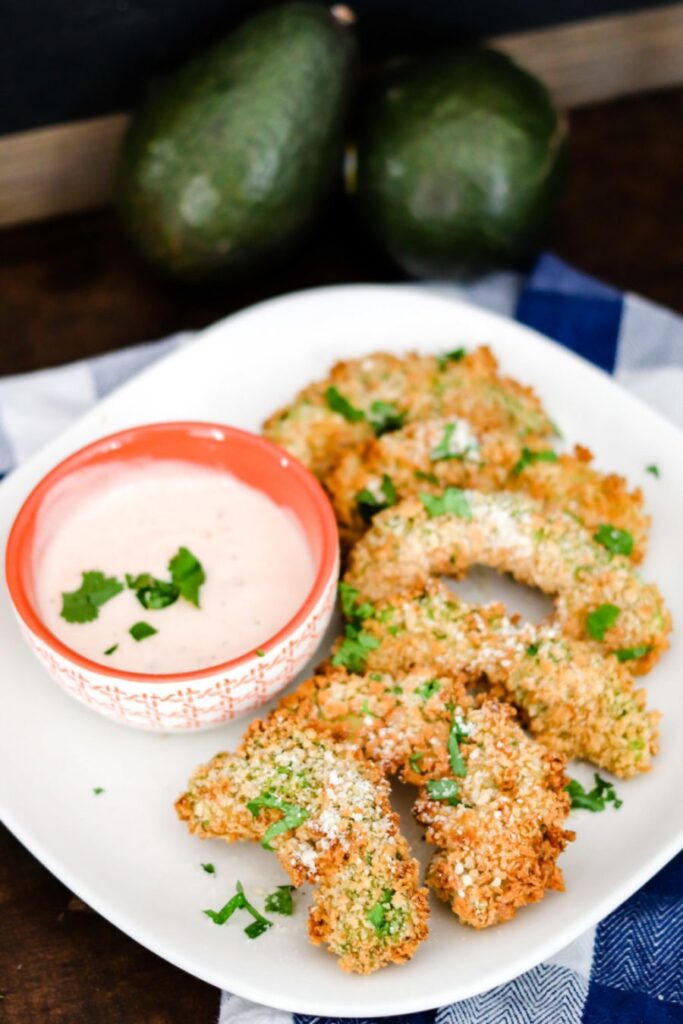 avocado fries on plate with a cream sauce in bowl 