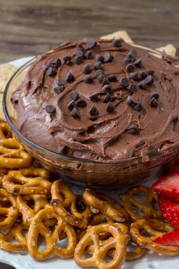 brownie batter in a bowl with dipping items around it 