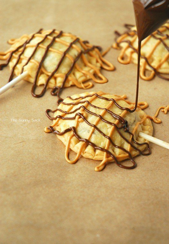 peanut butter cup hand pies on a stick with chocolate drizzled on top 