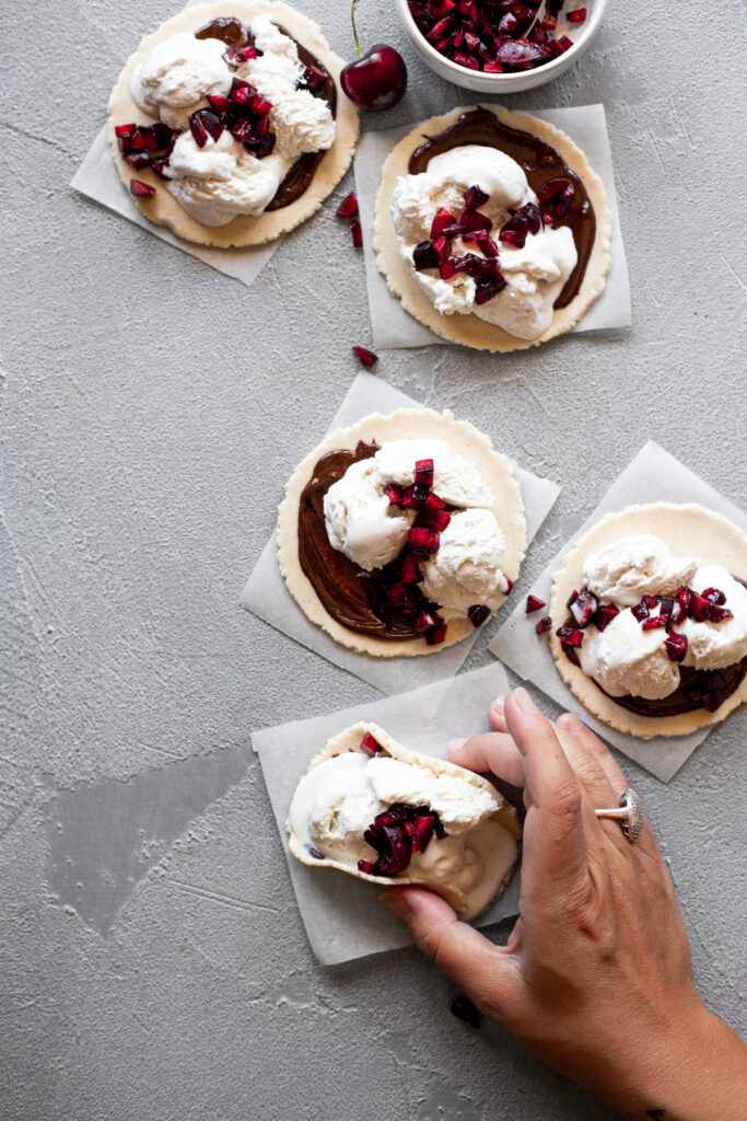 cookie dough tacos on counter with lifting one up 