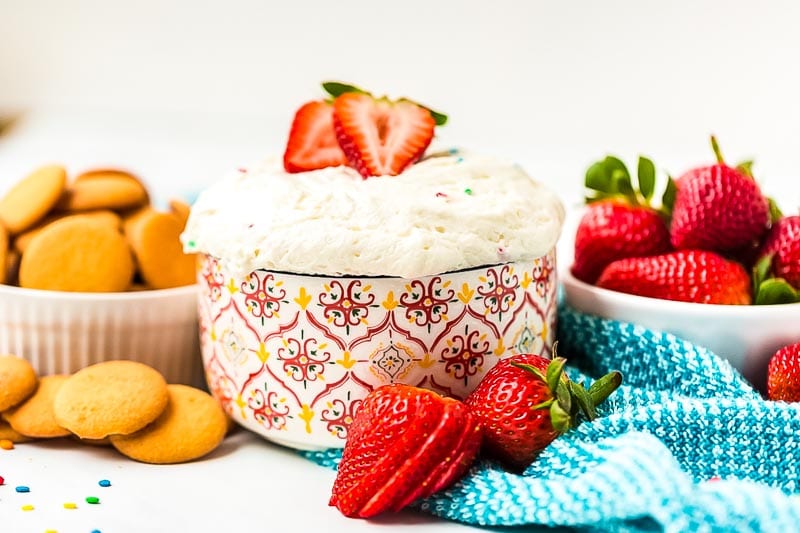 funfetti dip with fruit and cookies around bowl