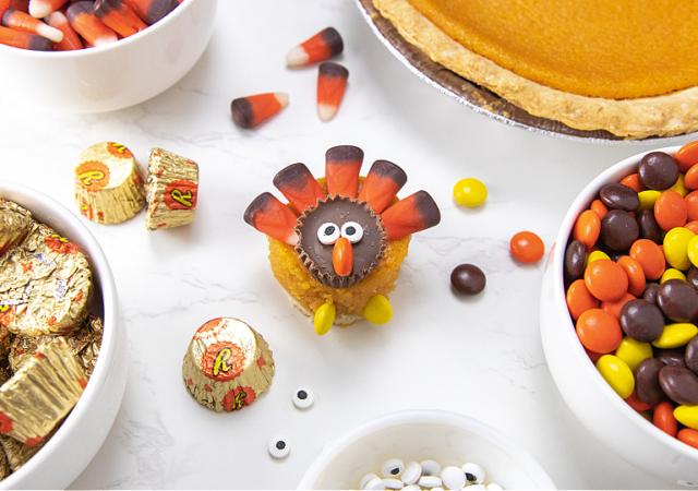 tirkey pumpkin pie on table with candies around it