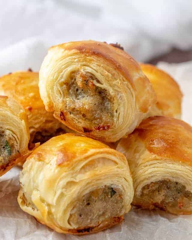 sausage rolls stacked on a plate 