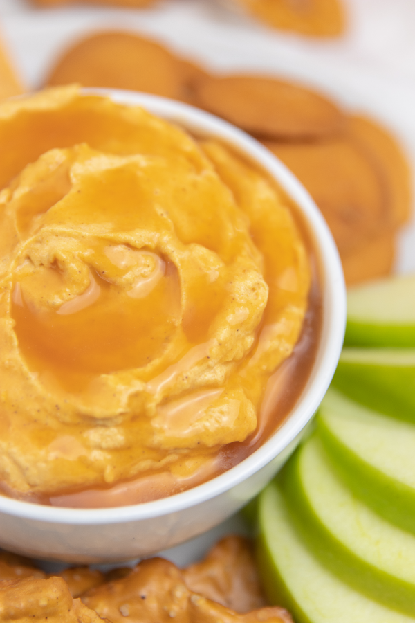 A super simple caramel pumpkin pie cheesecake dip that takes just 4 ingredients to make. Serve this up as a fun party dip for fall! Creamy cheesecake dip flavored with pumpkin and caramel. #passion4savings #caramel #pumpkin #dip #cheesecake #nobake #dessert #partyfood close up of pumpkin caramel dip