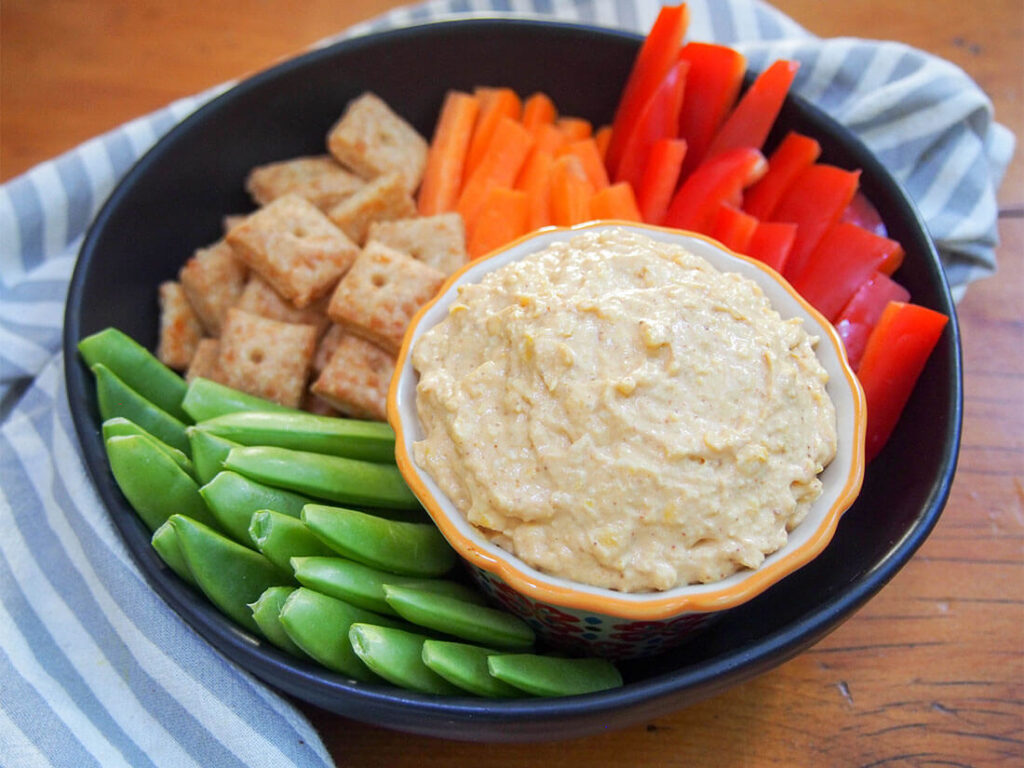 pumpkin dip with veggies around it in a bowl 