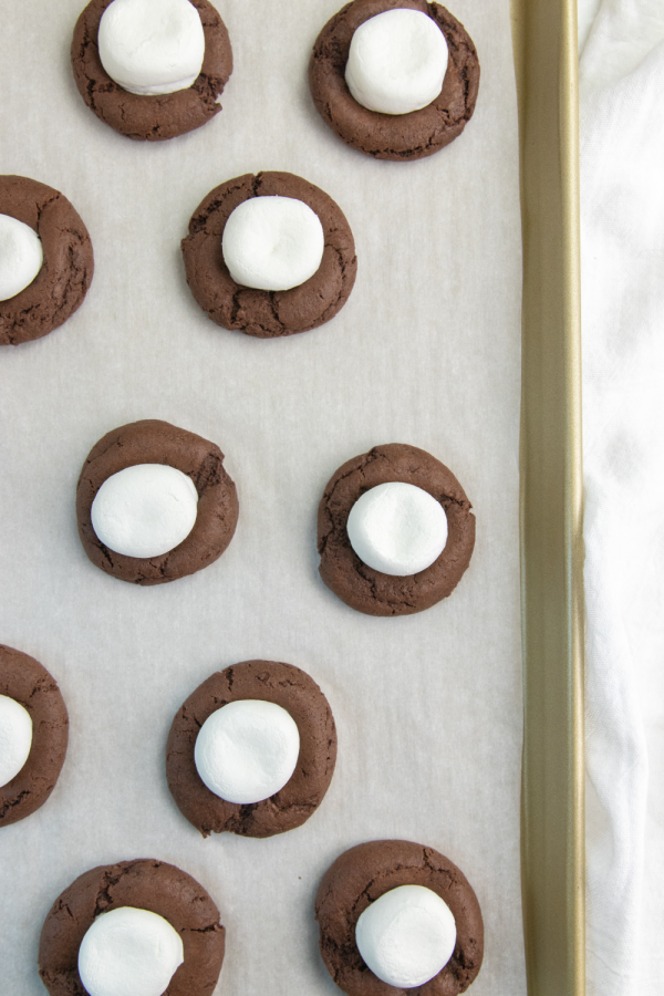 Serve up these easy hot chocolate cookies today. These are a cute and fun chocolate cookie topped with marshmallow and chocolate! Try today. #hotchocolate #cocoacookies #dessert #passion4savings #dessertidea #holiday #christmas #winter #cakemix #devilsfood holiday cookies on cookie sheet